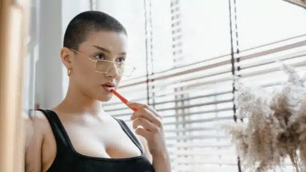 Woman in Eyeglasses Putting Lipstick